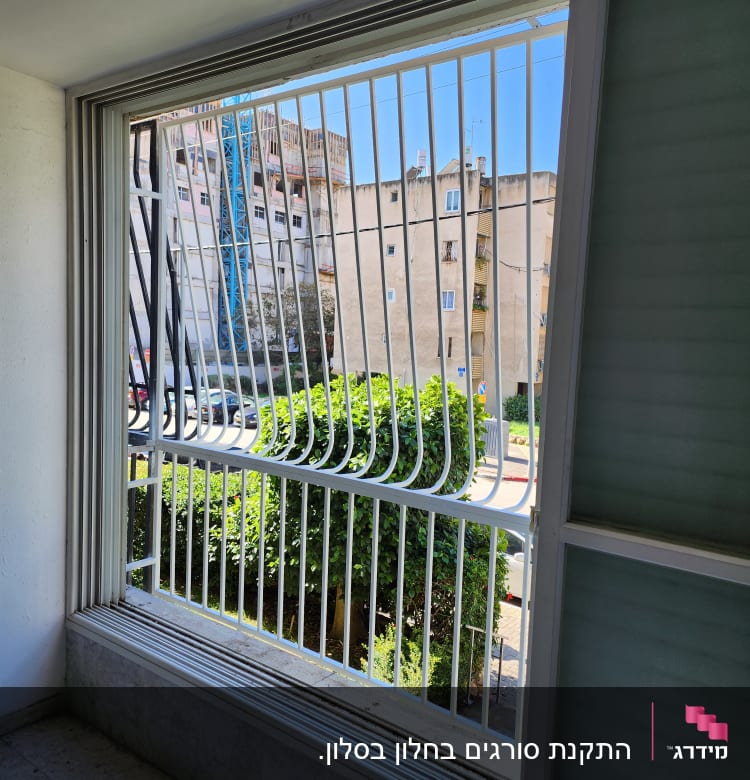 סורגי מתכת לבנים בחלון פתוח